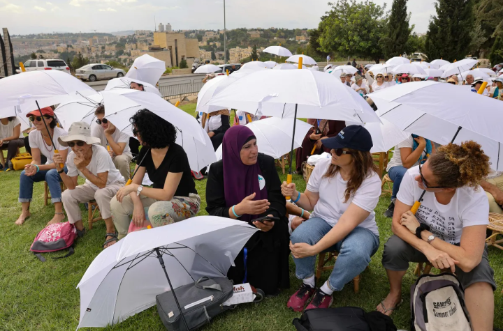 Aktivis berkumpul di sekitar Monumen Toleransi di Yerusalem pada 4 Oktober 2023, dalam sebuah acara yang diselenggarakan oleh gerakan Perempuan Israel Menggerakan Perdamaian dan Perempuan Matahari Palestina. Foto oleh Menahem Kahana/AFP melalui Getty Images